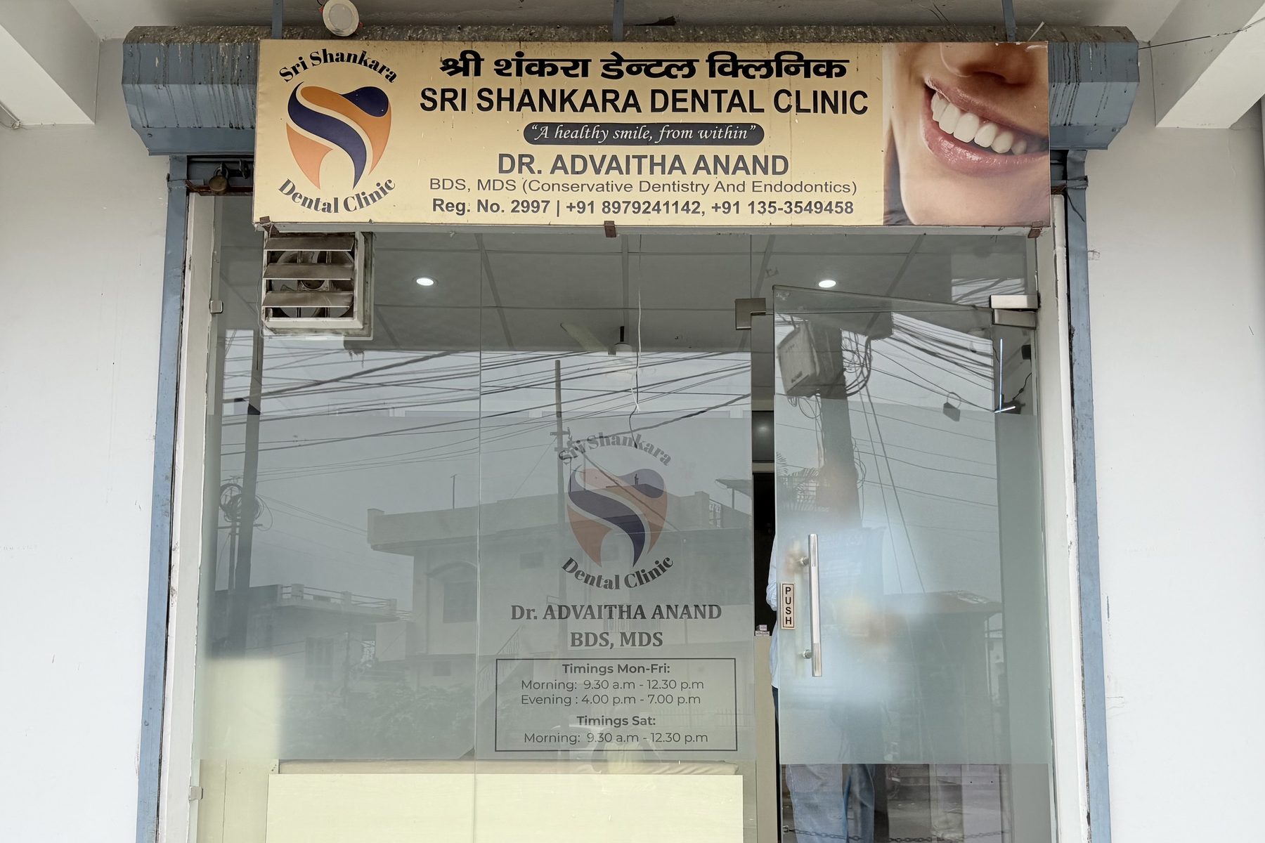 The entrance to Sri Shankara Dental Clinic on Nalapani Road, Tapovan Enclave, with the clinic sign above the glass frontage and the opening hours on the door.